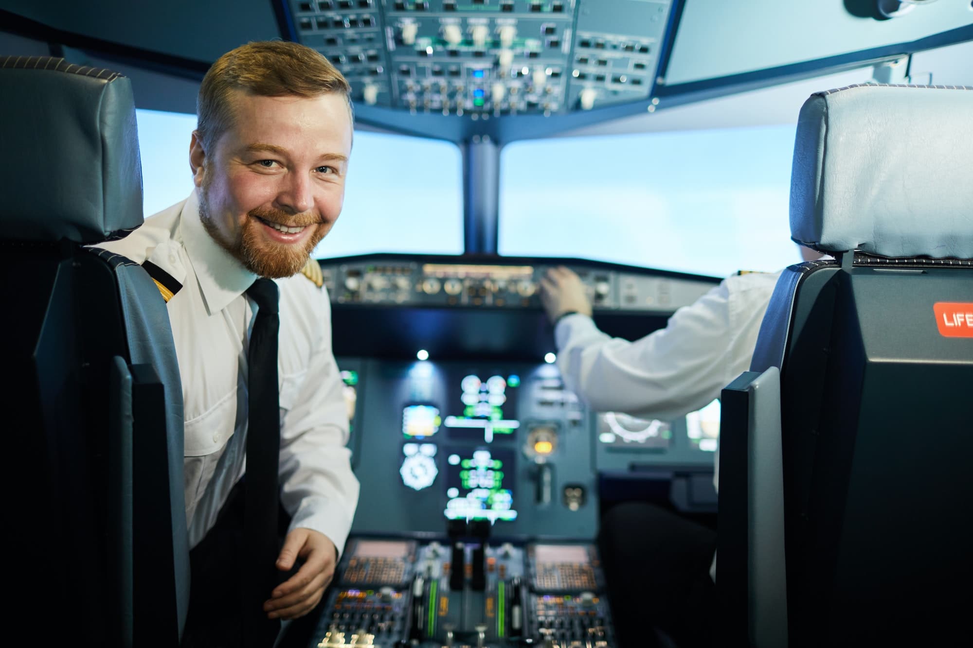 Confident bearded pilot in cockpit